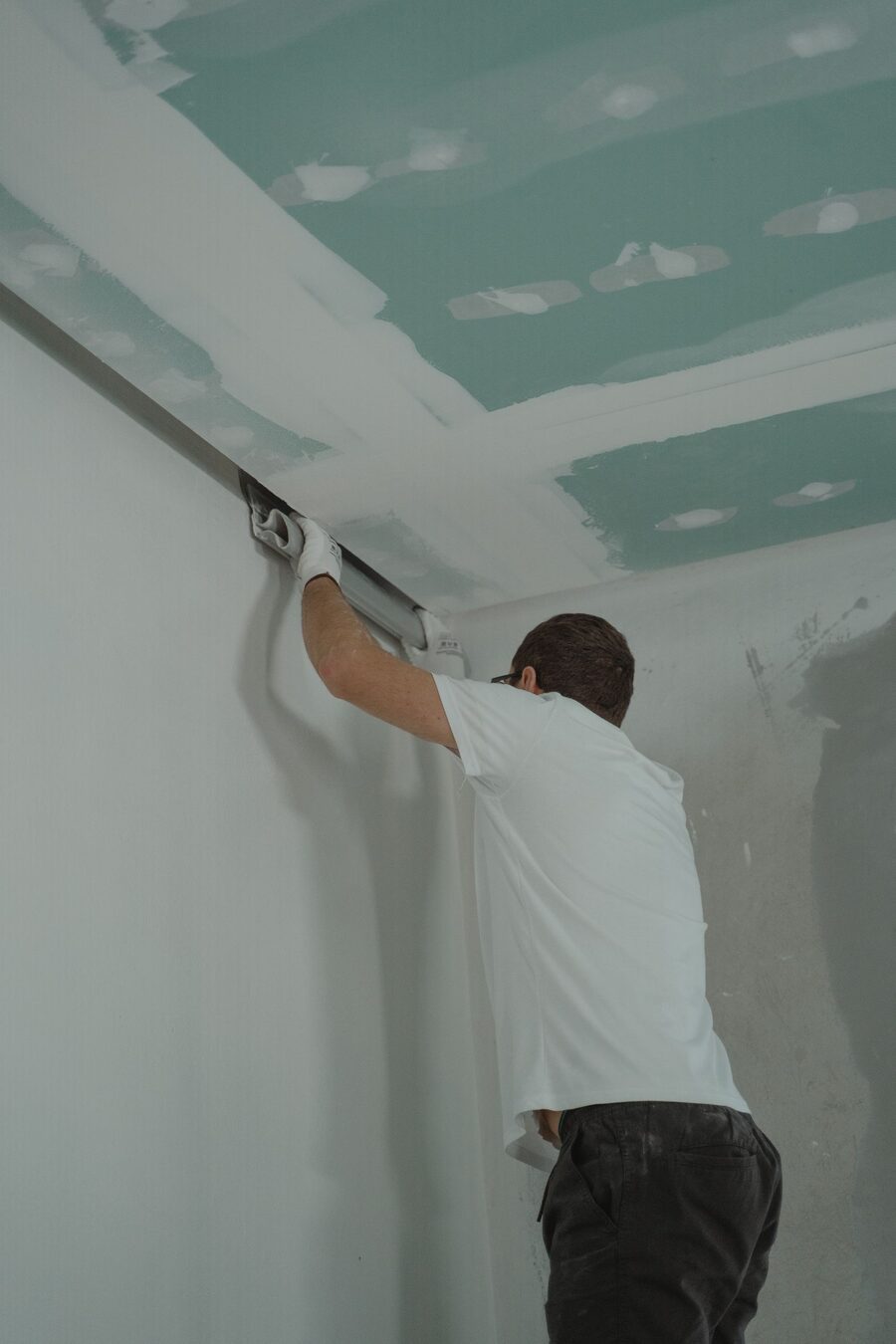 Handwerker spachtelt eine Gipskartondecke im Rohbau